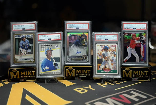 Five PSA graded cards from an inbound collection standing on Mint By Memphis display stands after arrival.