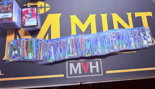 A long row of sleeved cards from an inbound collection laid across the Mint By Memphis table.