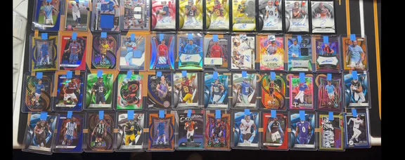 Basketball, football and soccer inserts and autographs from an inbound collection, laid out in rows for review.