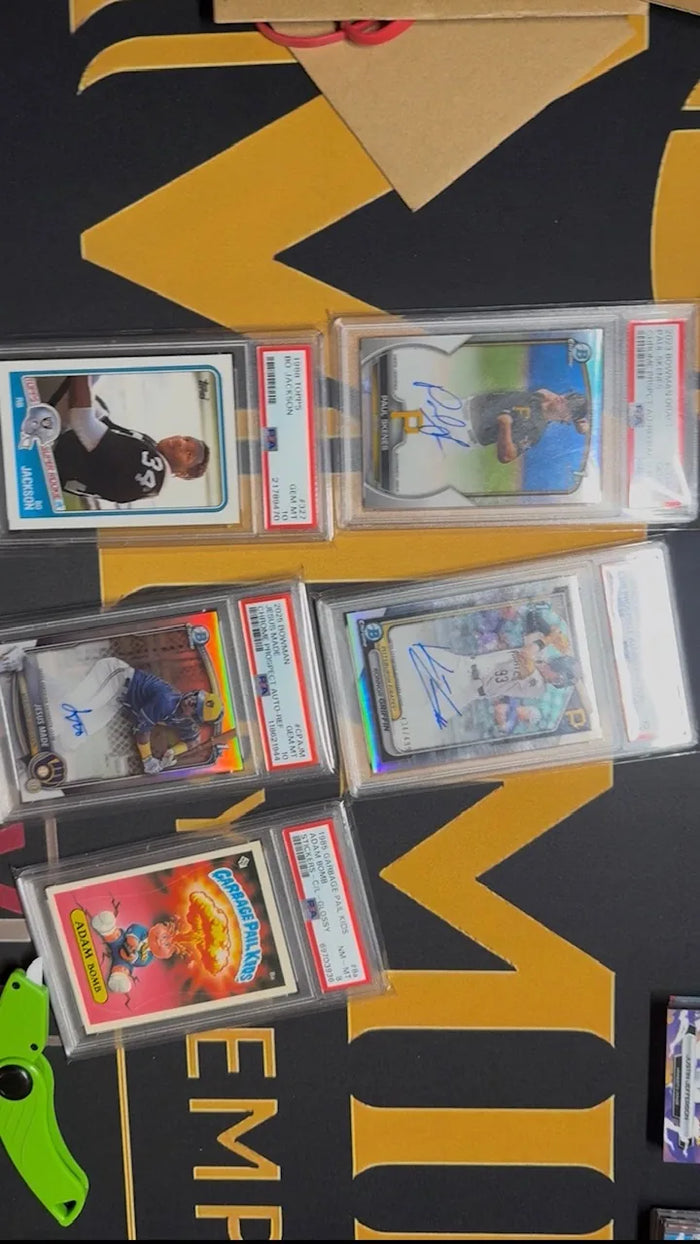 Overhead view of five PSA graded cards from an inbound collection laid out on the Mint By Memphis mat just after the package was opened.