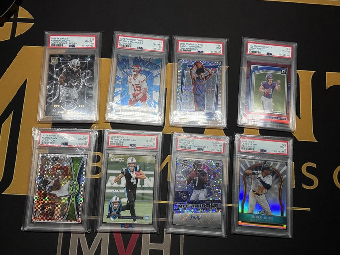 Eight PSA graded football and baseball cards from a newly arrived collection laid out on the Mint By Memphis mat.