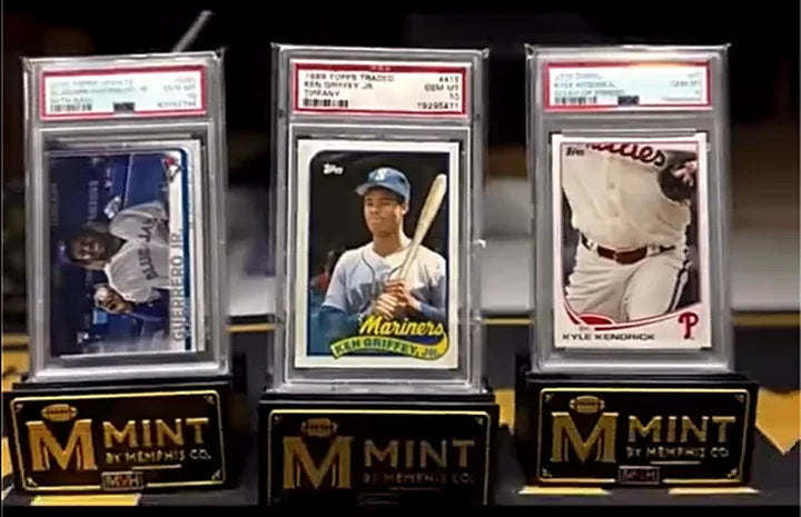 Three PSA gem-mint standouts from the collection, Vladimir Guerrero Jr, a 1989 Topps Traded Ken Griffey Jr, and Kyle Kendrick, on Mint by Memphis display stands