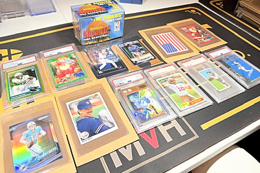 Graded slabs and raw sports card rookies laid out on the Mint by Memphis mat after arrival and verification
